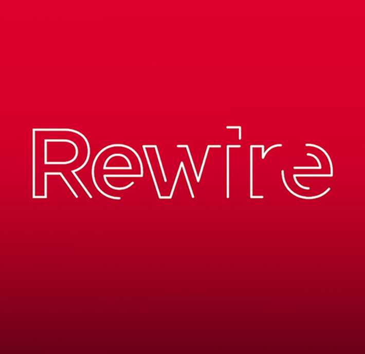 The image features the word "Rewire" in a modern, thin white font against a red gradient background. The letters "i" and "e" are stylized, with the "e" resembling a backward "3" and part of the "i" extending above the line.